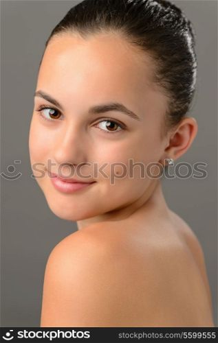 Teenage girl bare shoulders skin beauty face portrait on gray