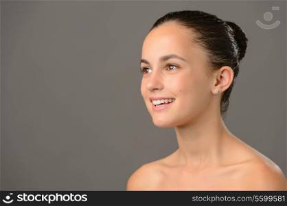 Teenage girl bare shoulders skin cosmetics beauty smiling on gray background