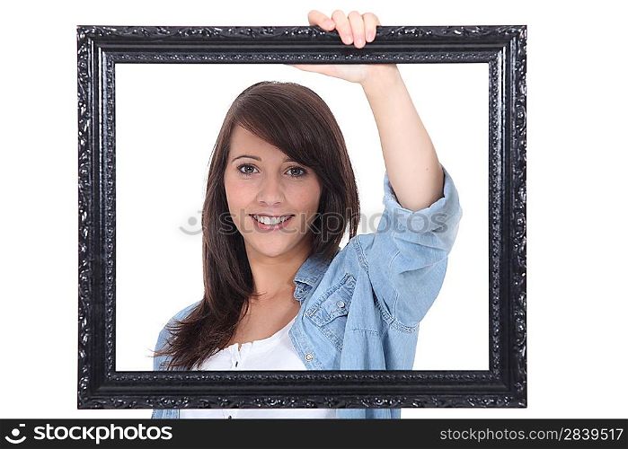 teenage girl behind a painting frame