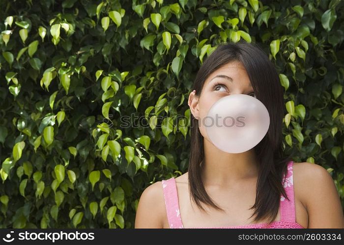 Teenage girl blowing a bubble gum