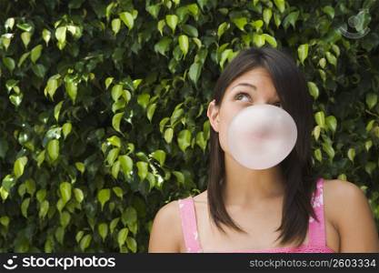 Teenage girl blowing a bubble gum