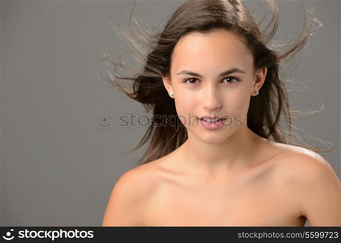 Teenage girl blowing hair skin beauty sensual on gray background