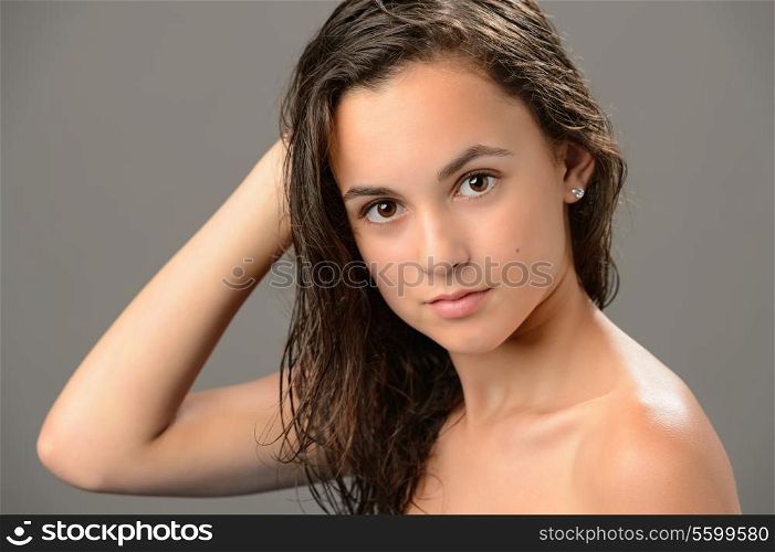 Teenage girl brunette wet hair beauty skin on gray background