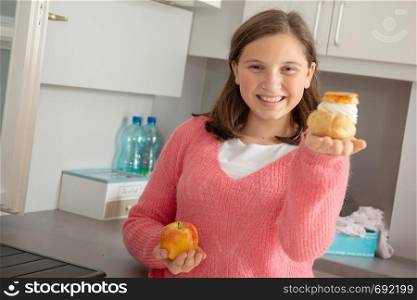 teenage girl chosen with a sweet pastry and organic apple