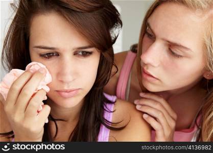 Teenage girl comforting tearful friend