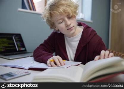 Teenage Girl Doing Homework At Desk In Bedroom