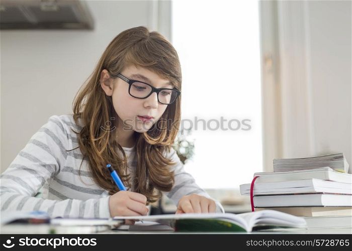 Teenage girl doing homework at table