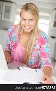 Teenage girl doing homework with laptop