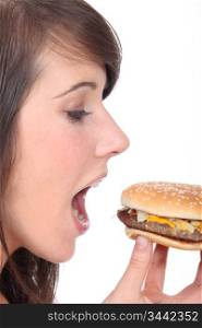teenage girl eating an hamburger