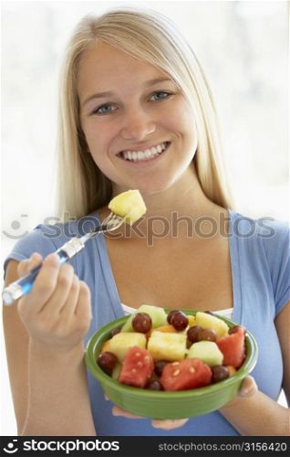Teenage Girl Eating Fresh Fruit Salad