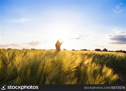Teenage girl enjoy with sunshine in wheat field. Catch the sun. Girl on sunset