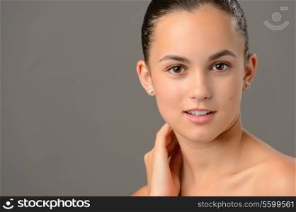 Teenage girl face cosmetics skin care close-up on gray background