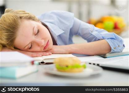 Teenage girl fall asleep while studying in kitchen