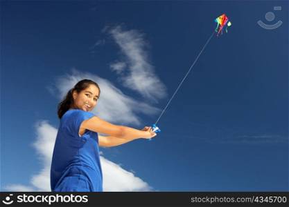 Teenage girl flying a kite