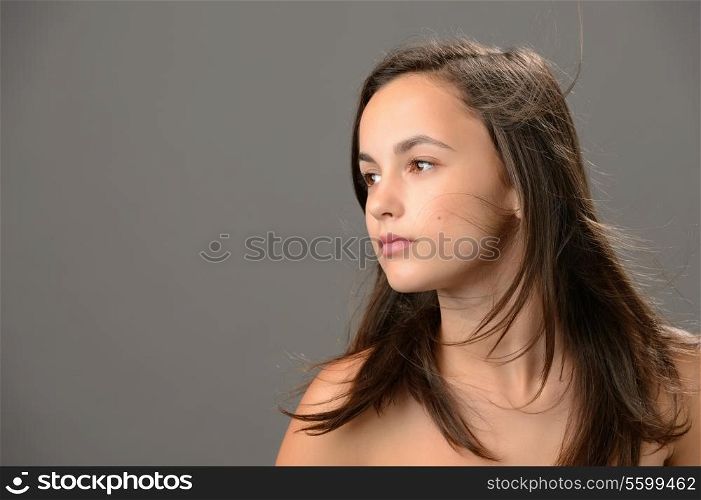 Teenage girl hair beauty skin looking away on gray background