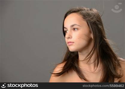 Teenage girl hair beauty skin looking away on gray background