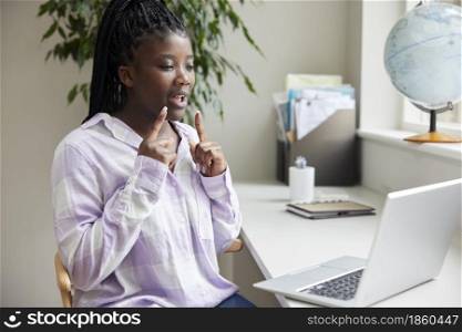 Teenage Girl Having Conversation Using Sign Language On Laptop At Home