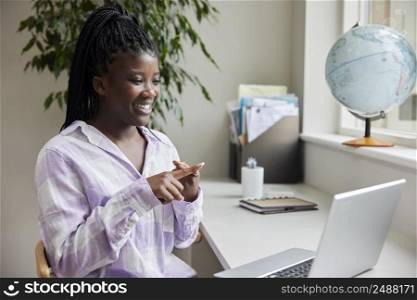 Teenage Girl Having Conversation Using Sign Language On Laptop At Home