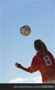 Teenage Girl Heading Soccer Ball