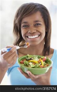 Teenage Girl Holding A Bowl Of Salad And Smiling At The Camera