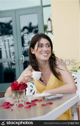 Teenage girl holding a cup of tea and smiling