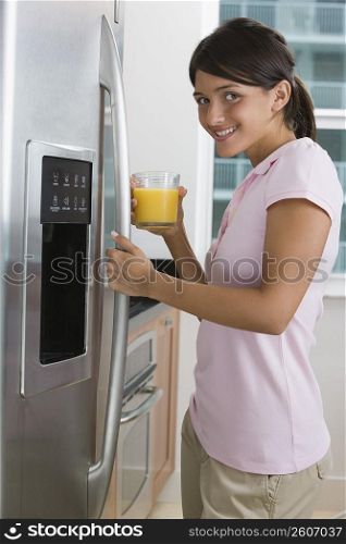 Teenage girl holding a glass of orange juice