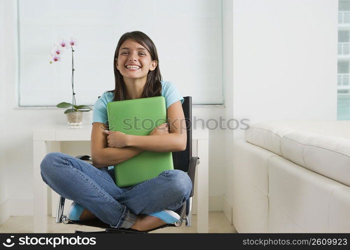 Teenage girl holding a laptop