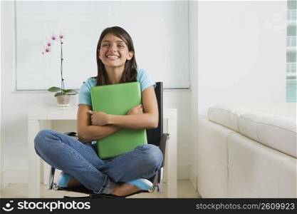 Teenage girl holding a laptop
