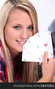 Teenage girl holding the winning card hand of four aces