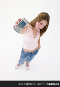 Teenage girl holding up cellular phone and frowning