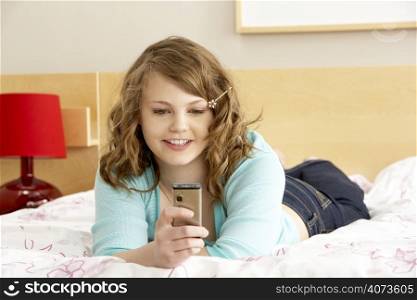 Teenage Girl In Bedroom With Mobile Phone