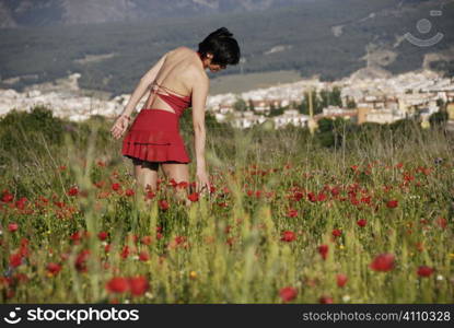 Teenage girl in field of wildflowers, Granada, Andalusia