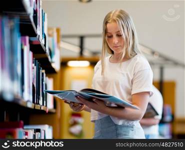 teenage girl in library choosing books. Teenage girl in library