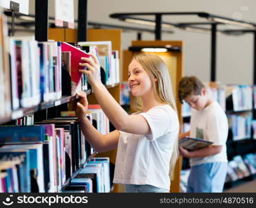 teenage girl in library choosing books. Teenage girl in library