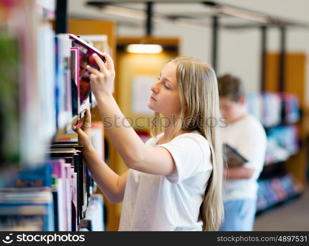 teenage girl in library choosing books. Teenage girl in library