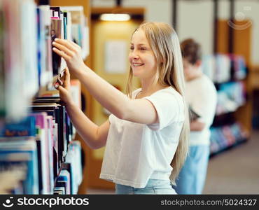 teenage girl in library choosing books. Teenage girl in library