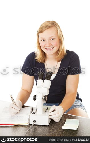 Teenage girl in school, taking notes on what she observed through the microscope. Isolated on white.