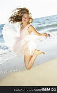 Teenage Girl Jumping In Air On Beach Holiday