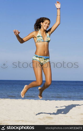 Teenage girl jumping on the beach