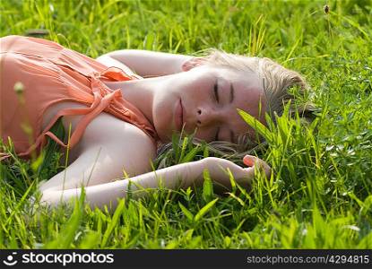 Teenage girl laying in tall grass