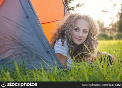 Teenage girl laying in tent at campsite