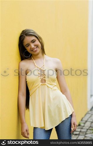 Teenage girl leaning against a wall