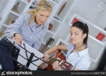 teenage girl learning to play the guitar