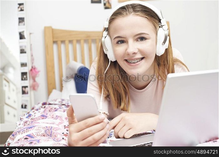 Teenage Girl Listening To Music Whilst Using Mobile Phone