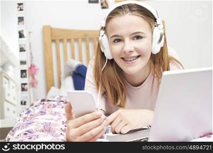 Teenage Girl Listening To Music Whilst Using Mobile Phone