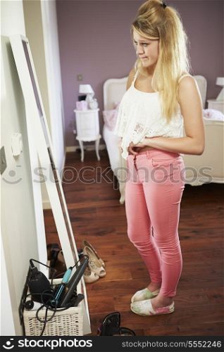 Teenage Girl Looking At Reflection In Bedroom Mirror