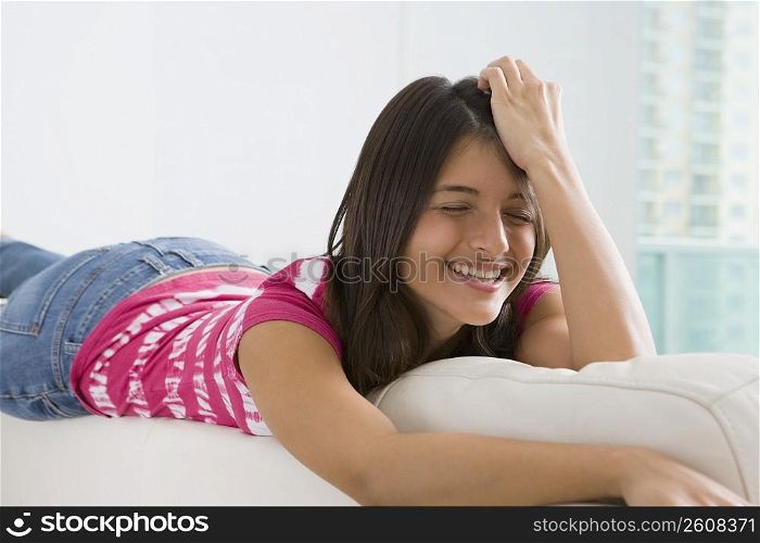 Teenage girl lying on a couch and smiling
