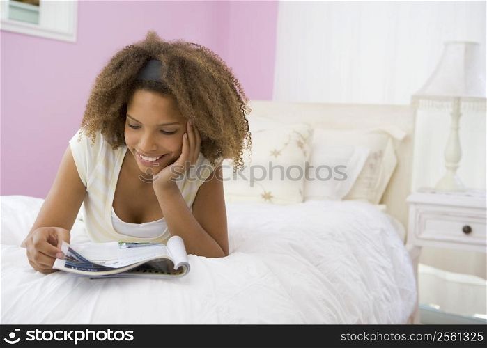 Teenage Girl Lying On Bed Reading