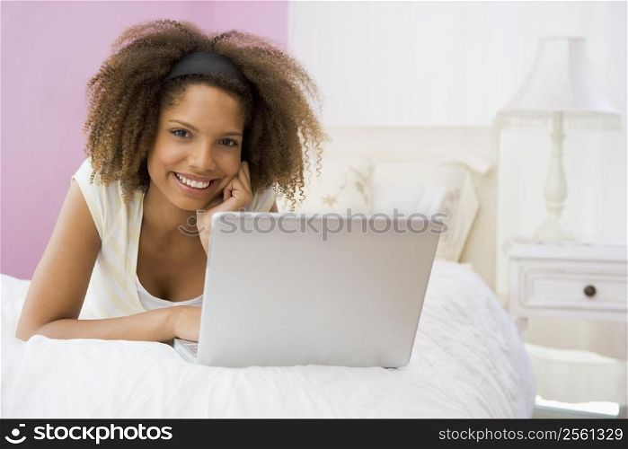 Teenage Girl Lying On Bed Using Laptop