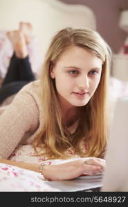 Teenage Girl Lying On Bed Using Laptop
